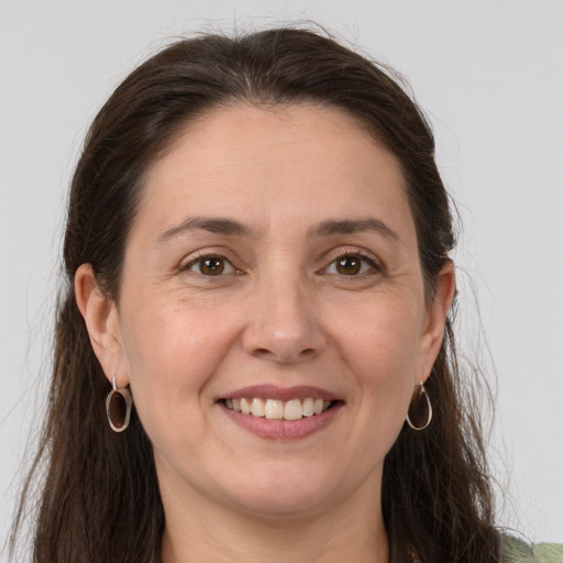 Joyful white adult female with long  brown hair and brown eyes