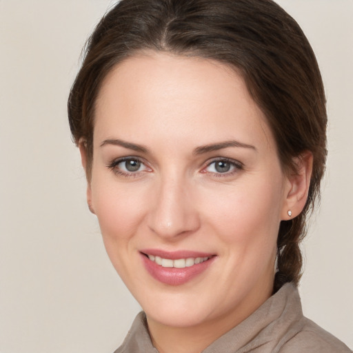 Joyful white young-adult female with medium  brown hair and grey eyes