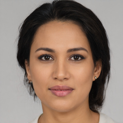 Joyful latino young-adult female with medium  brown hair and brown eyes