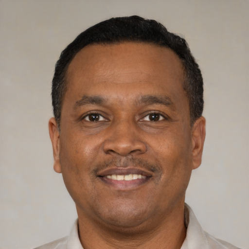 Joyful black adult male with short  black hair and brown eyes