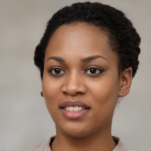 Joyful black young-adult female with short  black hair and brown eyes