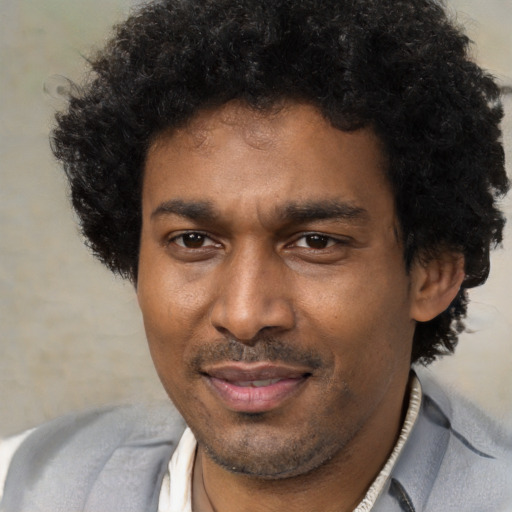 Joyful black adult male with short  brown hair and brown eyes