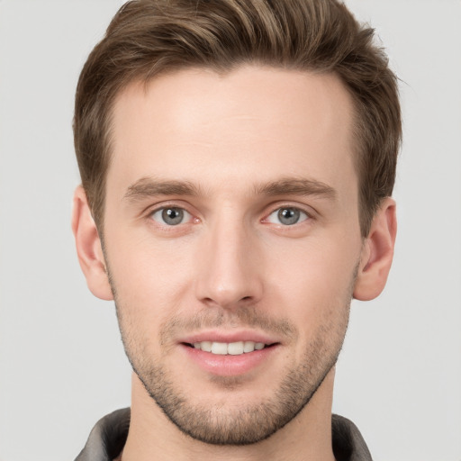 Joyful white young-adult male with short  brown hair and grey eyes