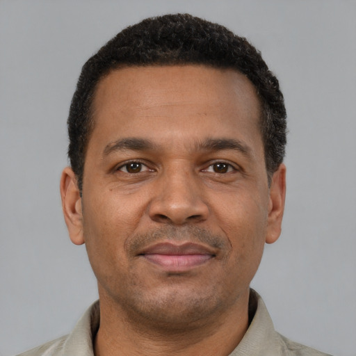 Joyful latino young-adult male with short  brown hair and brown eyes