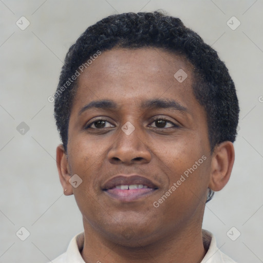 Joyful black young-adult male with short  brown hair and brown eyes