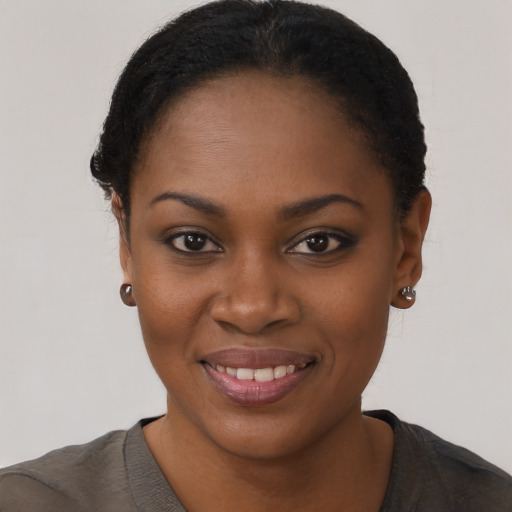 Joyful black young-adult female with short  black hair and brown eyes