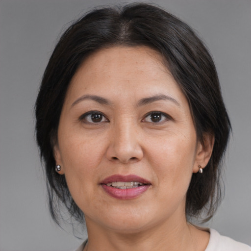 Joyful asian adult female with medium  brown hair and brown eyes