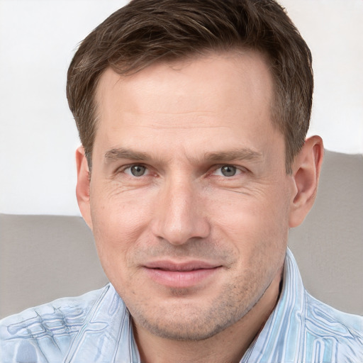 Joyful white adult male with short  brown hair and grey eyes