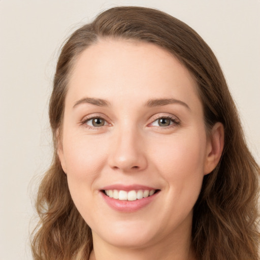 Joyful white young-adult female with long  brown hair and green eyes