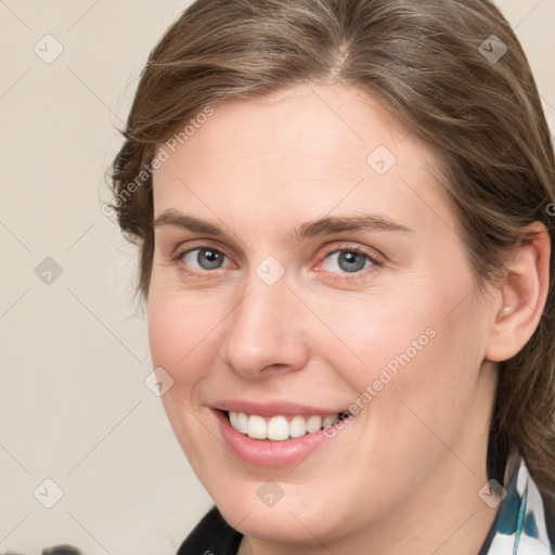 Joyful white young-adult female with medium  brown hair and blue eyes