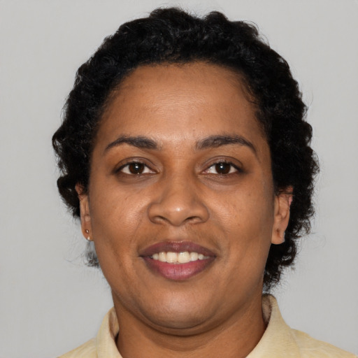 Joyful black adult female with short  black hair and brown eyes