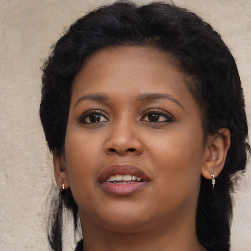 Joyful black young-adult female with long  brown hair and brown eyes