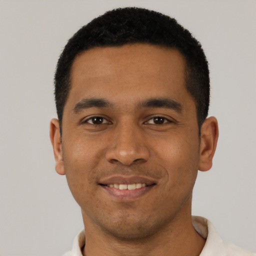 Joyful black young-adult male with short  black hair and brown eyes