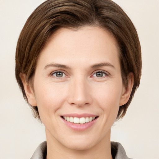 Joyful white young-adult female with medium  brown hair and grey eyes