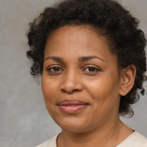 Joyful black adult female with short  brown hair and brown eyes