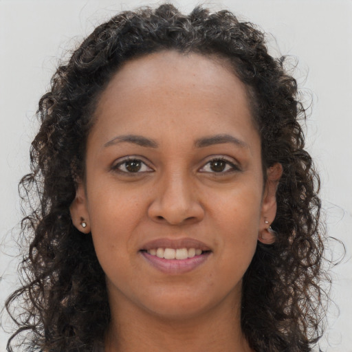Joyful black young-adult female with long  brown hair and brown eyes