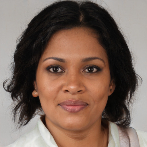Joyful black adult female with medium  brown hair and brown eyes