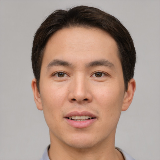 Joyful asian young-adult male with short  brown hair and brown eyes