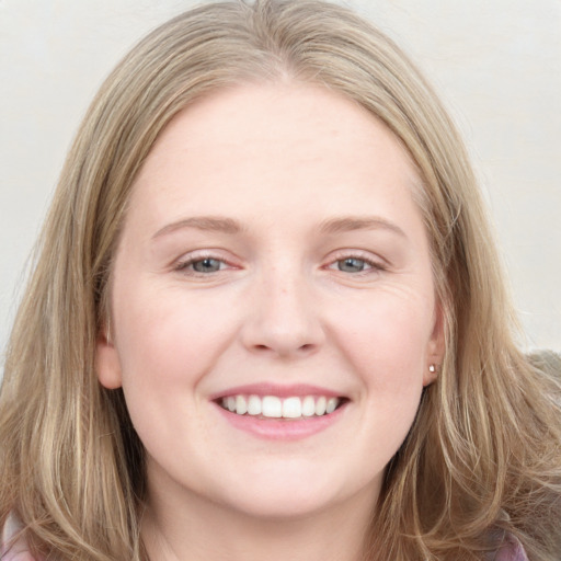 Joyful white young-adult female with long  brown hair and blue eyes