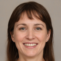 Joyful white young-adult female with medium  brown hair and grey eyes