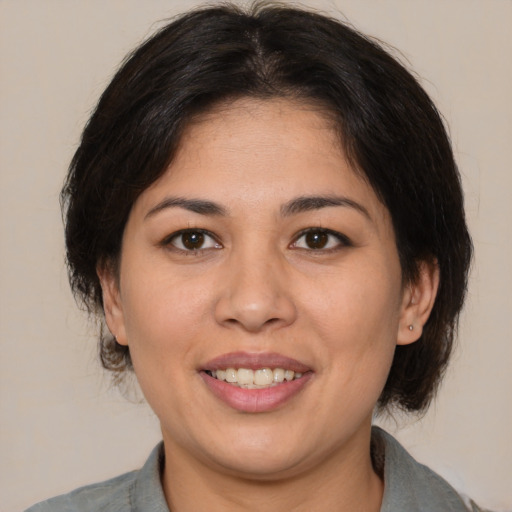 Joyful latino young-adult female with medium  brown hair and brown eyes