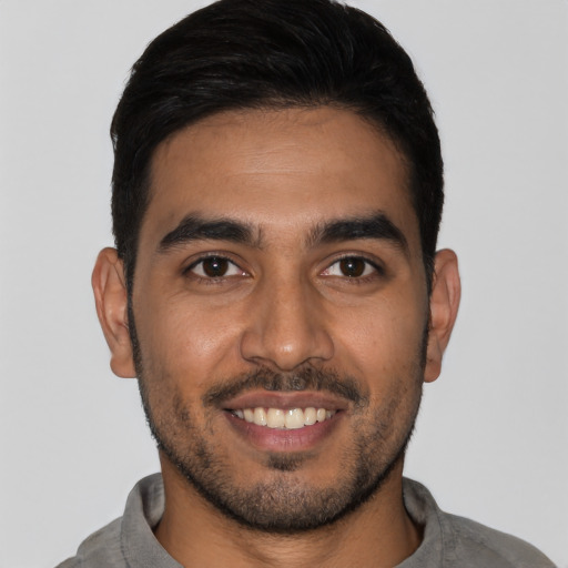 Joyful latino young-adult male with short  black hair and brown eyes