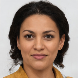 Joyful latino young-adult female with medium  brown hair and brown eyes