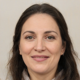 Joyful white adult female with long  brown hair and brown eyes