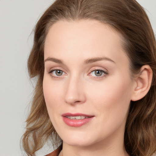 Joyful white young-adult female with long  brown hair and blue eyes