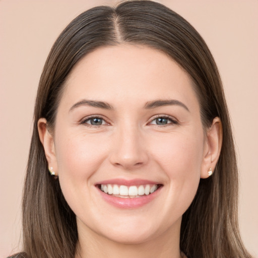 Joyful white young-adult female with long  brown hair and brown eyes