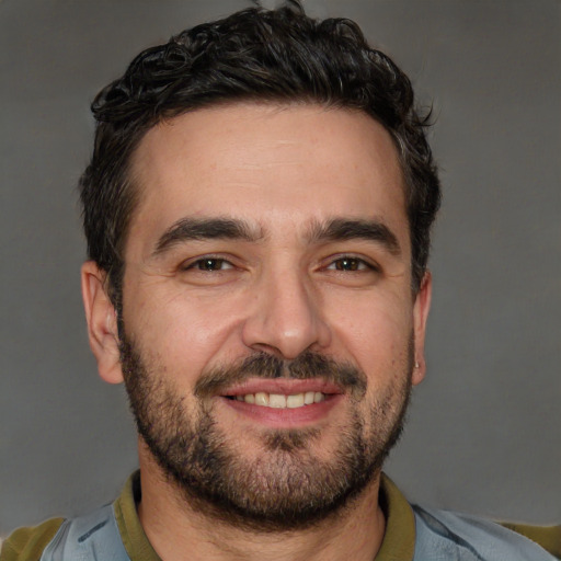 Joyful white adult male with short  black hair and brown eyes