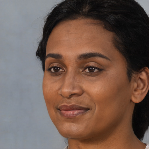 Joyful black adult female with medium  black hair and brown eyes