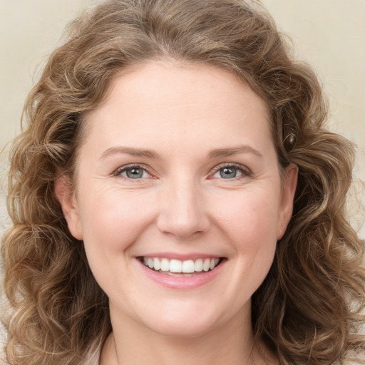 Joyful white young-adult female with long  brown hair and green eyes