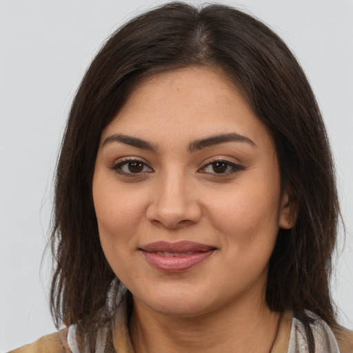 Joyful latino young-adult female with long  brown hair and brown eyes