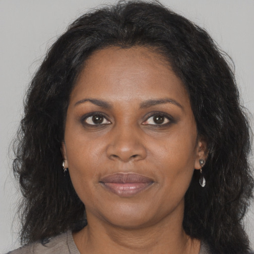 Joyful black adult female with long  brown hair and brown eyes