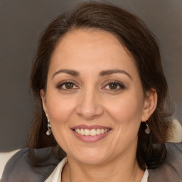 Joyful white adult female with medium  brown hair and brown eyes