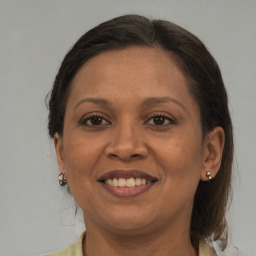 Joyful black adult female with medium  brown hair and brown eyes