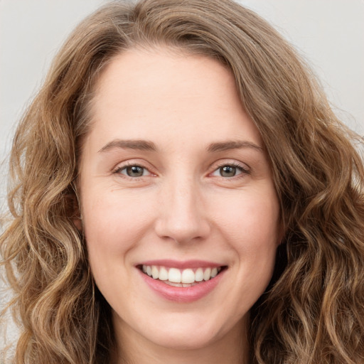 Joyful white young-adult female with long  brown hair and green eyes