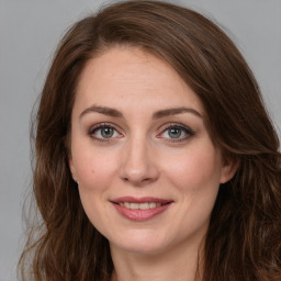 Joyful white young-adult female with long  brown hair and green eyes