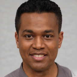 Joyful latino young-adult male with short  black hair and brown eyes