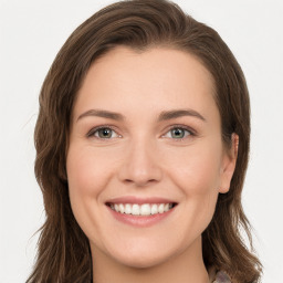 Joyful white young-adult female with long  brown hair and green eyes