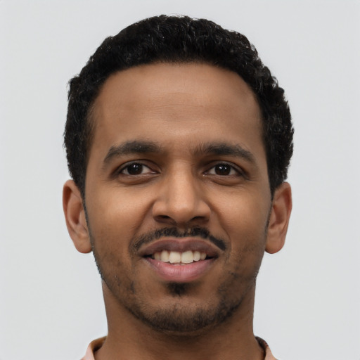 Joyful latino young-adult male with short  black hair and brown eyes