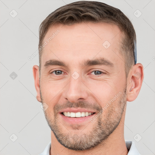 Joyful white young-adult male with short  brown hair and brown eyes