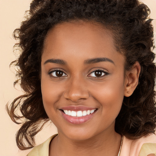 Joyful black young-adult female with long  brown hair and brown eyes