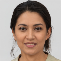 Joyful latino young-adult female with medium  brown hair and brown eyes