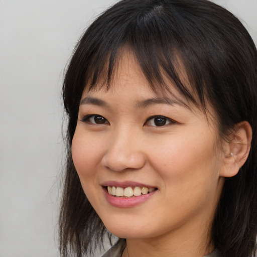 Joyful asian young-adult female with long  brown hair and brown eyes