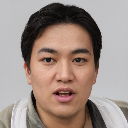 Joyful asian young-adult male with short  black hair and brown eyes