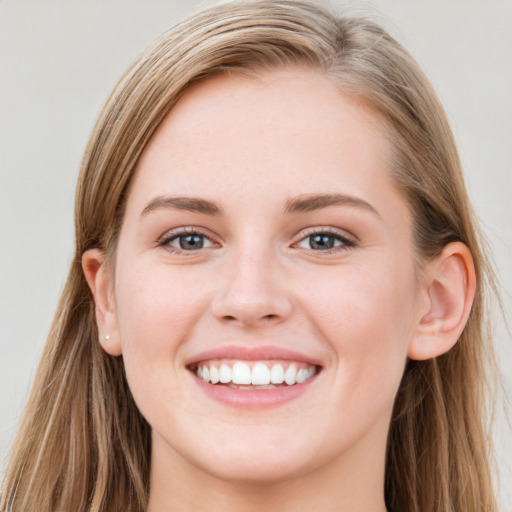 Joyful white young-adult female with long  brown hair and blue eyes