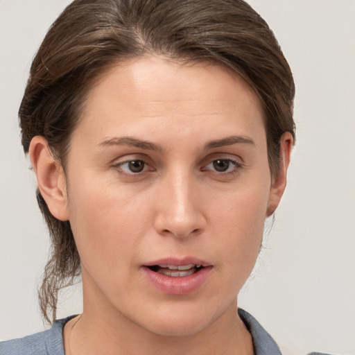 Joyful white young-adult female with medium  brown hair and grey eyes