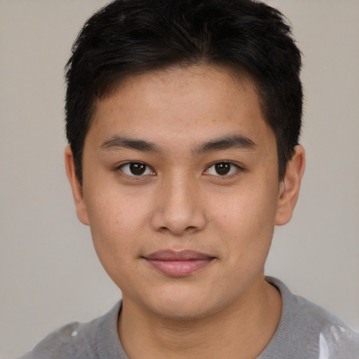 Joyful asian young-adult male with short  brown hair and brown eyes